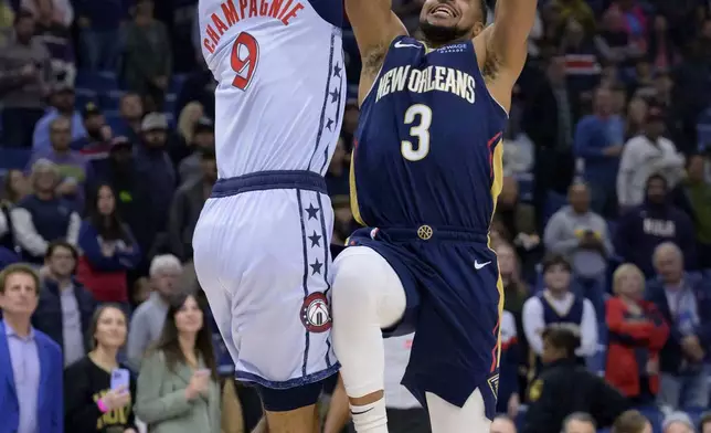 New Orleans Pelicans guard CJ McCollum (3) shoots against Washington Wizards forward Justin Champagnie (9) during the first half of an NBA basketball game in New Orleans, Friday, Jan. 3, 2025. (AP Photo/Matthew Hinton)