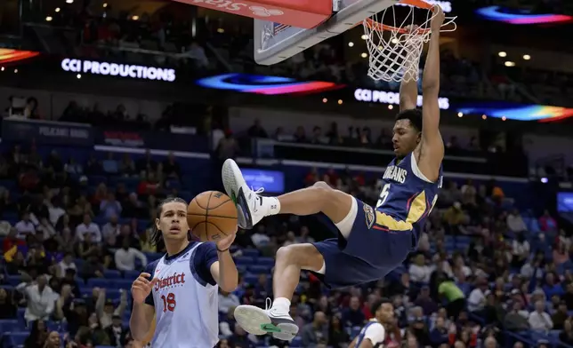 New Orleans Pelicans guard Trey Murphy III, right, dunks against Washington Wizards forward Kyshawn George (18) during the first half of an NBA basketball game in New Orleans, Friday, Jan. 3, 2025. (AP Photo/Matthew Hinton)