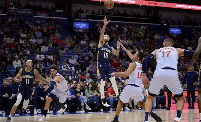 New Orleans Pelicans guard Jose Alvarado, center, shoots against Washington Wizards guard Malcolm Brogdon, center left, during the first half of an NBA basketball game in New Orleans, Friday, Jan. 3, 2025. (AP Photo/Matthew Hinton)