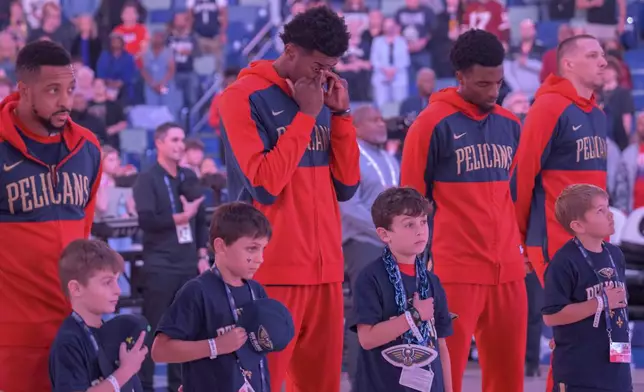 From top left to right, New Orleans Pelicans guard CJ McCollum, center Yves Missi, forward Herbert Jones and center Daniel Theis react after a moment of silence honoring the victims of the New Year's Day deadly attack on Bourbon Street before an NBA basketball game against the Washington Wizards in New Orleans, Friday, Jan. 3, 2025. (AP Photo/Matthew Hinton)