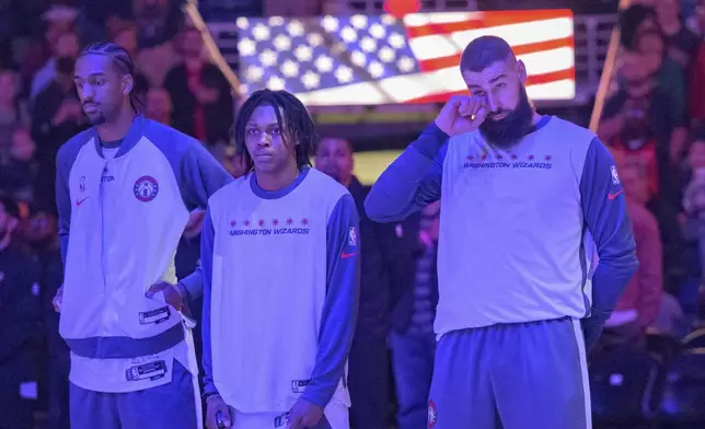 Washington Wizards center Jonas Valanciunas, right, who used to play for the New Orleans Pelicans, reacts after a moment of silence honoring the victims of the New Year's Day deadly attack on Bourbon Street before an NBA basketball game against the Pelicans in New Orleans, Friday, Jan. 3, 2025. (AP Photo/Matthew Hinton)