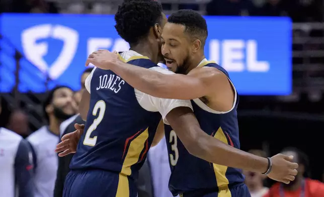 New Orleans Pelicans guard CJ McCollum (3) celebrates a 3-point basket with forward Herbert Jones (2) during the first half of an NBA basketball game against the Washington Wizards in New Orleans, Friday, Jan. 3, 2025. (AP Photo/Matthew Hinton)