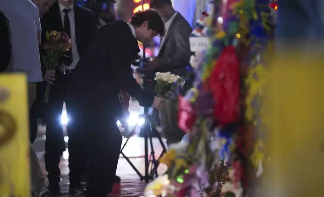 Friends of Kareem Badawi, a victim of the deadly truck attack on New Year's Day in New Orleans, place flowers at a memorial for victims after attending his funeral, Friday, Jan. 3, 2025. (AP Photo/Gerald Herbert)