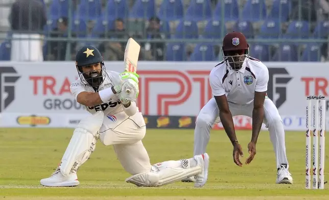 Pakistan's Mohammad Rizwan, left, plays a shot during the day one of the first test cricket match between Pakistan and West Indies, in Multan, Pakistan, Friday, Jan. 17, 2025. (AP Photo/Asim Tanveer)
