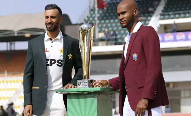 West Indies captain Kraigg Brathwaite, right, and his Pakistani counterpart Shan Masood pose for photo with test-series trophy, in Multan, Pakistan, Thursday, Jan. 16, 2025. (AP Photo/Asim Tanveer)