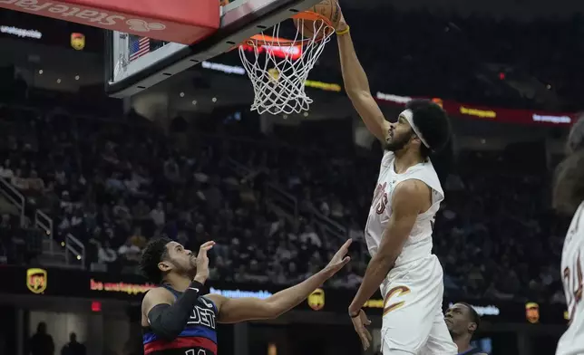 Cleveland Cavaliers center Jarrett Allen, right, dunks in front of Detroit Pistons forward Tobias Harris (12) in the first half of an NBA basketball game, Monday, Jan. 27, 2025, in Cleveland. (AP Photo/Sue Ogrocki)