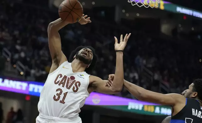 Cleveland Cavaliers center Jarrett Allen (31) is fouled by Detroit Pistons guard Ron Harper Jr., right, in the first half of an NBA basketball game, Monday, Jan. 27, 2025, in Cleveland. (AP Photo/Sue Ogrocki)