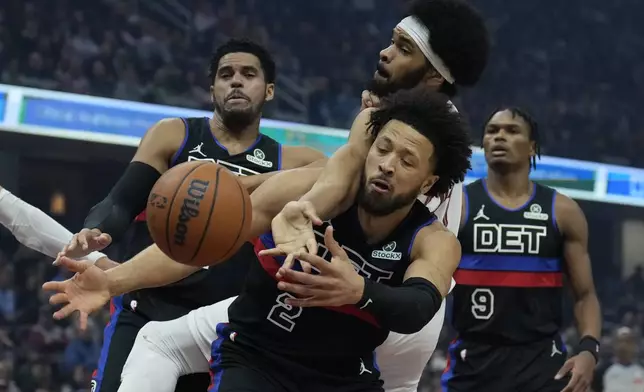 Detroit Pistons forward Tobias Harris, left, Cleveland Cavaliers center Jarrett Allen, center top, and Pistons' Cade Cunningham (2) reach for a rebound in the first half of an NBA basketball game, Monday, Jan. 27, 2025, in Cleveland. (AP Photo/Sue Ogrocki)