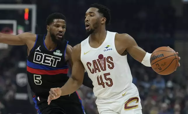 Cleveland Cavaliers guard Donovan Mitchell (45) drives past Detroit Pistons guard Malik Beasley (5) in the first half of an NBA basketball game, Monday, Jan. 27, 2025, in Cleveland. (AP Photo/Sue Ogrocki)