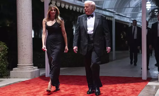 Melania Trump looks on as President-elect Donald Trump arrives for a New Year's Eve party at Mar-a-Lago, Tuesday, Dec. 31, 2024, in Palm Beach, Fla. (AP Photo/Evan Vucci)