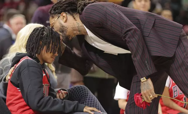 Former NBA player Derrick Rose, right, kisses his son PJ Rose, left, after a half- time ceremony during an NBA basketball game between the New York Knicks and the Chicago Bulls, Saturday, Jan. 4, 2025, in Chicago. (AP Photo/Melissa Tamez)