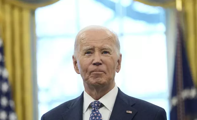 President Joe Biden pauses during a photo opportunity with Medal of Valor recipients in the Oval Office of the White House in Washington, Friday, Jan. 3, 2025. (AP Photo/Susan Walsh)