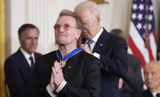 Bono gestures as President Joe Biden presents him with the Presidential Medal of Freedom, the Nation's highest civilian honor, in the East Room of the White House, Saturday, Jan. 4, 2025, in Washington. (AP Photo/Manuel Balce Ceneta)