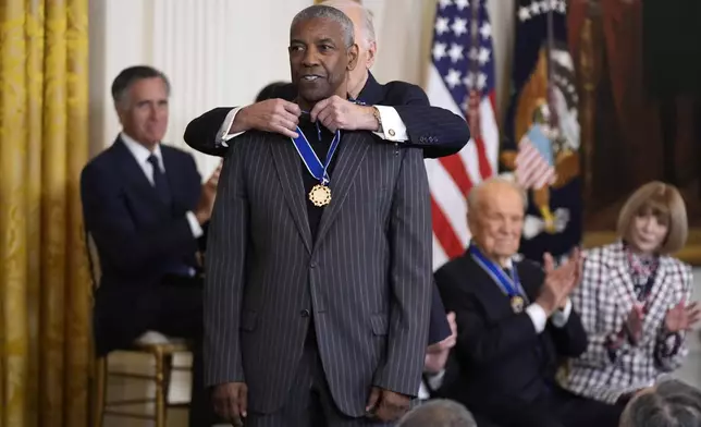 President Joe Biden, right, presents the Presidential Medal of Freedom, the Nation's highest civilian honor, to Denzel Washington in the East Room of the White House, Saturday, Jan. 4, 2025, in Washington. (AP Photo/Manuel Balce Ceneta)