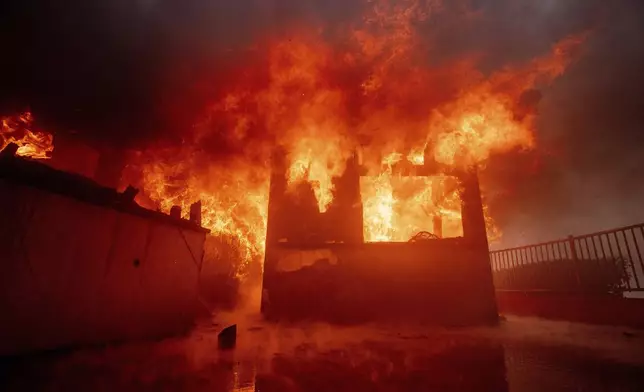 The Palisades Fire burns a property in the Pacific Palisades neighborhood of Los Angeles, Tuesday, Jan. 7, 2025. (AP Photo/Ethan Swope)