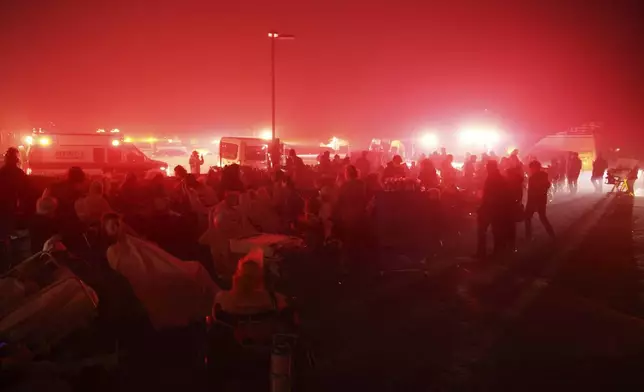 Residents of a senior center are evacuated as the Eaton Fire approaches Tuesday, Jan. 7, 2025, in Altadena, Calif. (AP Photo/Ethan Swope)