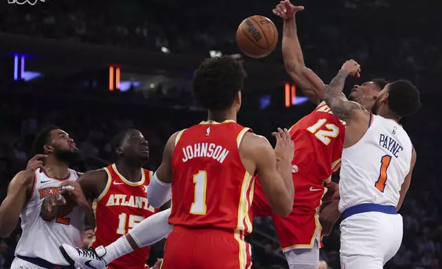 New York Knicks' Cameron Payne, right, fouls Atlanta Hawks' De'Andre Hunter (12) during the first half of an NBA basketball game, Monday, Jan. 20, 2025, in New York. (AP Photo/Heather Khalifa)