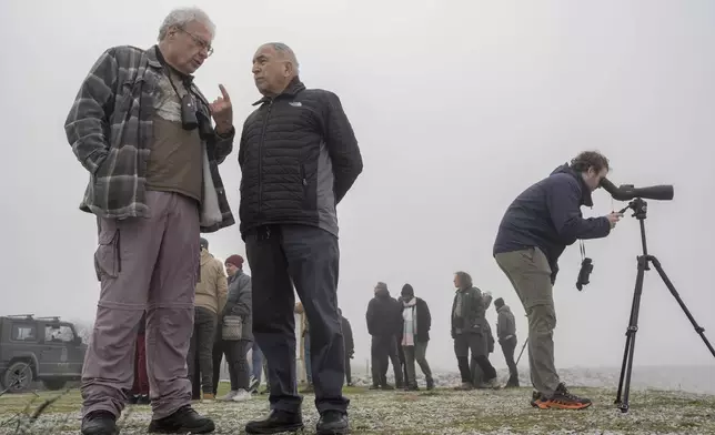 Yossi Leshem, professor emeritus at Tel Aviv University's School of Zoology, left, and retired Gen. Mansour Abu Rashid, former director of Jordanian military intelligence, chat as a birdwatcher look on through his monocular while fog covers the Karla lake, near the town of Stefanovikeio, Larissa, central Greece, on Jan. 22, 2025. (AP Photo/Petros Giannakouris)