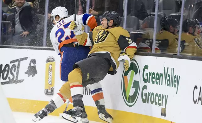 New York Islanders left wing Anders Lee (27) checks Vegas Golden Knights defenseman Brayden McNabb (3) during the first period of an NHL hockey game Thursday, Jan. 9, 2025, in Las Vegas. (AP Photo/Ian Maule)