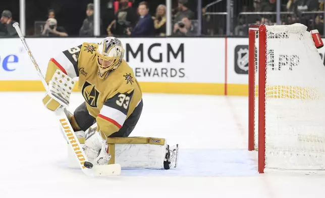 Vegas Golden Knights goaltender Adin Hill (33) passes the puck during the first period of an NHL hockey game against the New York Islanders, Thursday, Jan. 9, 2025, in Las Vegas. (AP Photo/Ian Maule)