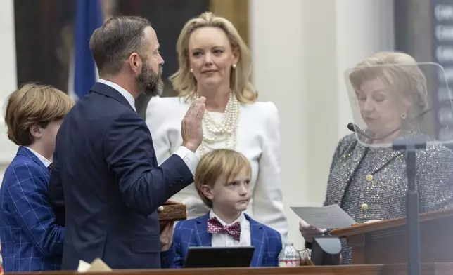 Texas state Rep. Dustin Burrows, R-Lubbock, left, is sworn in as speaker with wife Elizabeth and Texas Secretary of State Jane Nelson during opening day of the 89th Texas Legislative Session in Austin, Texas, Tuesday, Jan. 14, 2025. (AP Photo/Stephen Spillman)