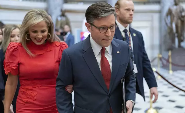 Speaker of the House Mike Johnson, R-La., accompanied by his wife Kelly Johnson, left, walks to the House Chamber before starting the 119th United States Congress at the Capitol in Washington, Friday, Jan. 3, 2025. (AP Photo/Jose Luis Magana)