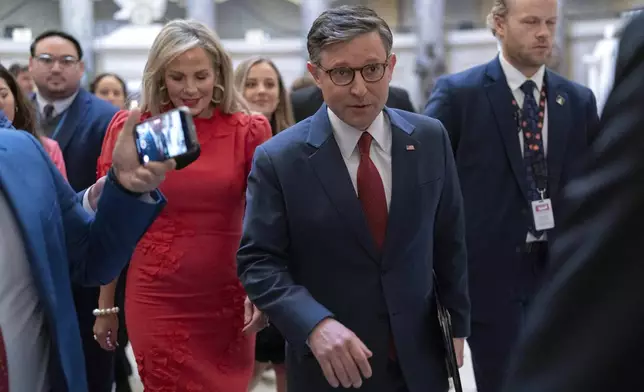 Speaker of the House Mike Johnson, R-La., accompanied by his wife Kelly Johnson, left, walks to the House Chamber before starting the 119th United States Congress at the Capitol in Washington, Friday, Jan. 3, 2025. (AP Photo/Jose Luis Magana)