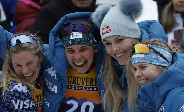 United States Lindsey Vonn poses with the American athletes of cross country after the 10km women's mass start race of the Tour de Ski cross country, in Val di Fiemme, Italy, Sunday, Jan. 5, 2025. (AP Photo/Alessandro Trovati)