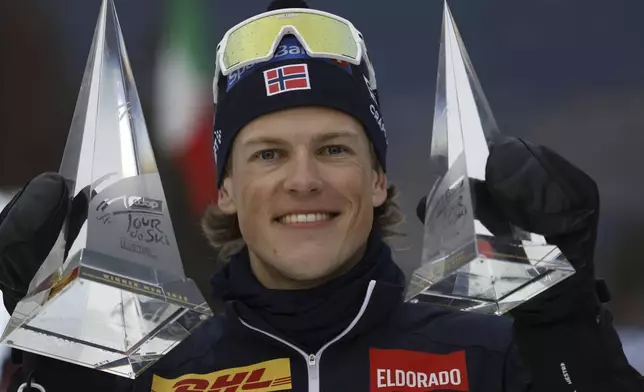 Tour de Ski winner Norway's Johannes Høsflot Klæbo poses with trophies after the 10km men's mass start race of the Tour de Ski cross country, in Val di Fiemme, Italy, Sunday, Jan. 5, 2025. (AP Photo/Alessandro Trovati)