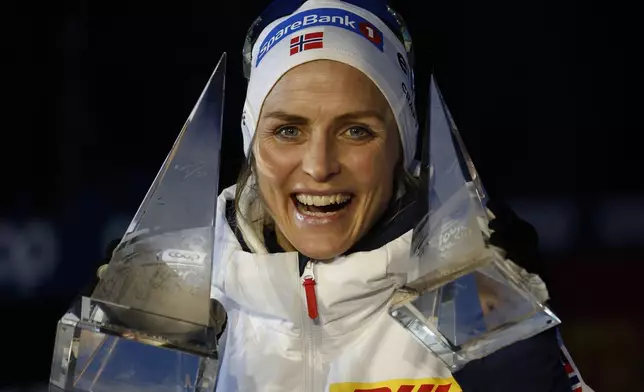 Tour de Ski winner Norway's Therese Johaug poses with her trophies after the 10km women's mass start race of the Tour de Ski cross country, in Val di Fiemme, Italy, Sunday, Jan. 5, 2025. (AP Photo/Alessandro Trovati)