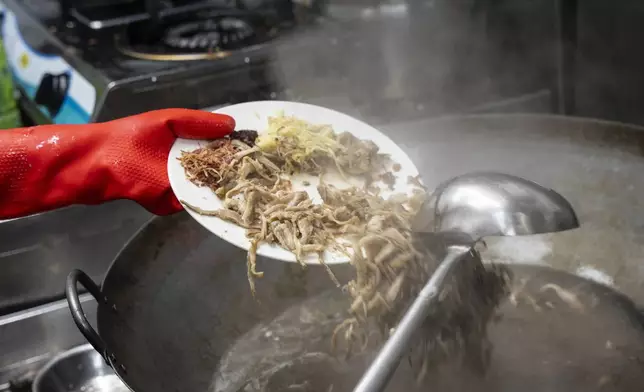 Chau Ka-ling, owner of the family-run snake soup restaurant, prepares snake soup in Hong Kong, Monday, Jan. 6, 2025. (AP Photo/Chan Long Hei)