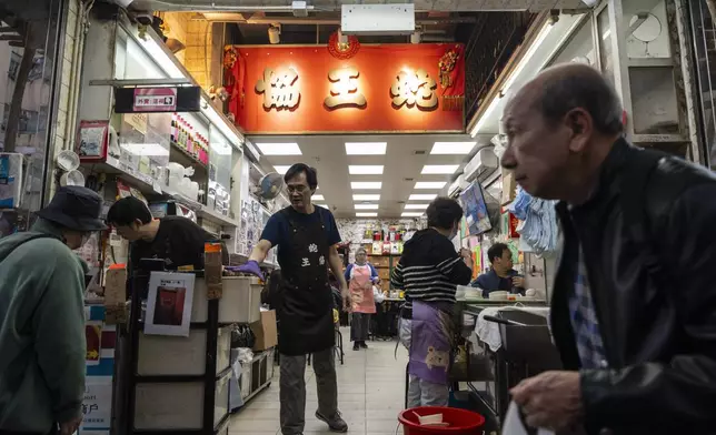 People walk past the family-run snake soup restaurant in Hong Kong, Monday, Jan. 6, 2025. (AP Photo/Chan Long Hei)