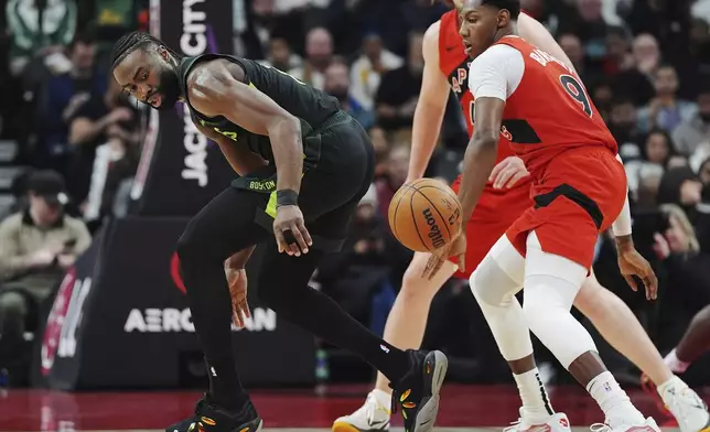 Toronto Raptors' RJ Barrett (9) strips the ball from Boston Celtics' Jaylen Brown (left) during first half NBA basketball action in Toronto on Wednesday, January 15, 2025. (Frank Gunn/The Canadian Press via AP)