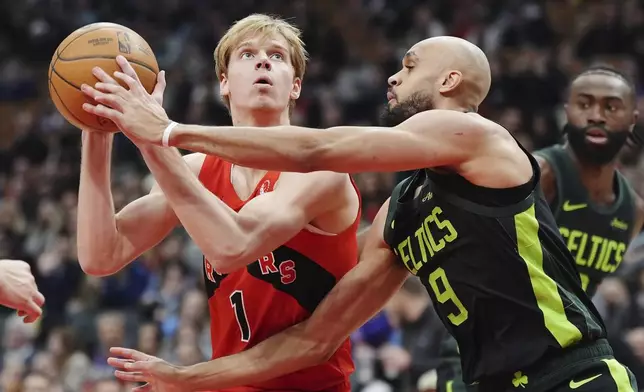 Toronto Raptors' Gradey Dick (1) is fouled by Boston Celtics' Derrick White (9) during first half NBA basketball action in Toronto on Wednesday, Jan. 15, 2025. (Frank Gunn/The Canadian Press via AP)