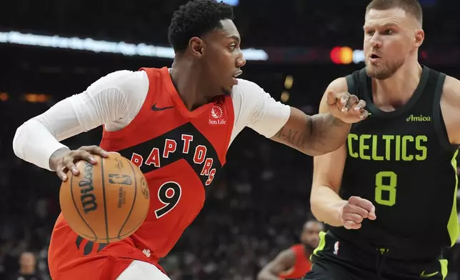 Toronto Raptors' RJ Barrett (9) drives as Boston Celtics' Kristaps Porzingis (8) defends during first half NBA basketball action in Toronto on Wednesday, January 15, 2025. (Frank Gunn/The Canadian Press via AP)