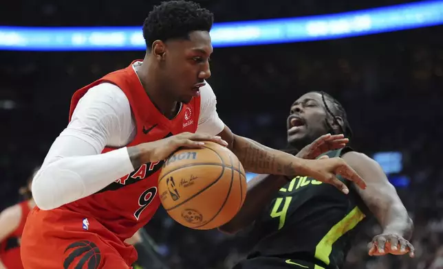 Toronto Raptors' RJ Barrett (9) drives at Boston Celtics' Jrue Holiday (4) during first half NBA basketball action in Toronto on Wednesday, January 15, 2025. (Frank Gunn/The Canadian Press via AP)