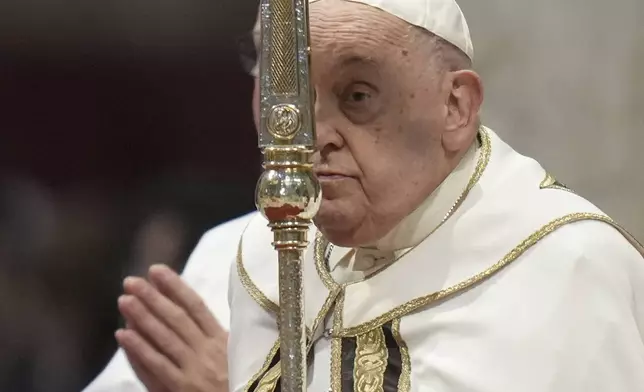 Pope Francis holds the cross as he presides over an Epiphany mass in St.Peter's Basilica, at the Vatican, Monday, Jan. 6, 2025. (AP Photo/Alessandra Tarantino)