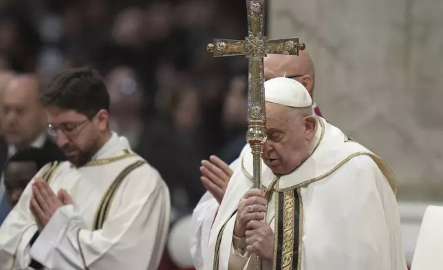 Pope Francis holds the cross as he presides over an Epiphany mass in St.Peter's Basilica, at the Vatican, Monday, Jan. 6, 2025. (AP Photo/Alessandra Tarantino)