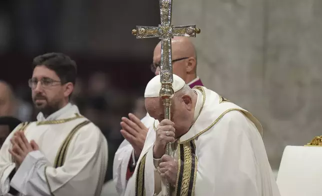 Pope Francis holds the cross as he presides over an Epiphany mass in St.Peter's Basilica, at the Vatican, Monday, Jan. 6, 2025. (AP Photo/Alessandra Tarantino)