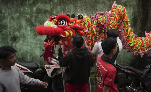 Members of dragon dance club Naga Merah Putih (Red White Dragon) which named after Indonesian national colors, prepare a dragon puppet before leaving for a shopping mall to perform in a Lunar New Year celebration, in Bogor, West Java, Indonesia, Sunday, Jan. 26, 2025. (AP Photo/Dita Alangkara)