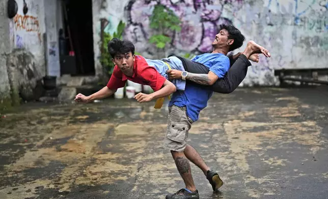 Muhammad Hisyam, left, and Aji Permana, members of dragon dance club Naga Merah Putih (Red White Dragon) which is named after Indonesian national colors, practice in Bogor, West Java, Indonesia, Friday, Jan. 24, 2025. (AP Photo/Dita Alangkara)