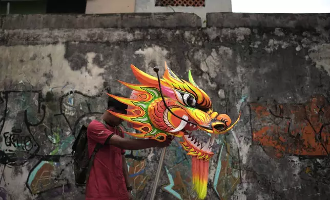 A member of dragon dance club Naga Merah Putih (Red White Dragon) which is named after Indonesian national colors, holds the head of a dragon puppet prepared for a performance in a Lunar New Year celebration, in Bogor, West Java, Indonesia, Sunday, Jan. 26, 2025. (AP Photo/Dita Alangkara)