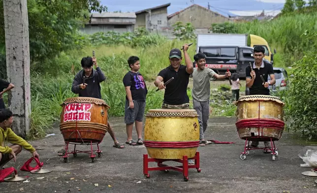 Members of dragon dance club Naga Merah Putih (Red White Dragon), named after Indonesian national colors, practice drumming days ahead of a performance, in Bogor, West Java, Indonesia, Wednesday, Jan. 22, 2025. (AP Photo/Dita Alangkara)