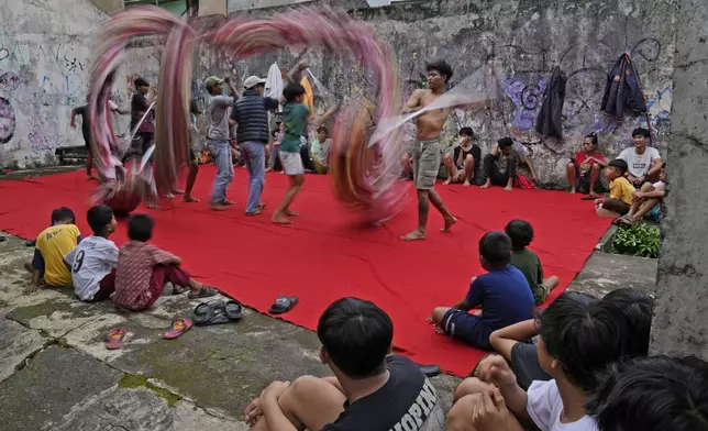 Members of dragon dance club Naga Merah Putih (Red White Dragon) which is named after Indonesian national colors, practice as local residents watch in Bogor, West Java, Indonesia, Wednesday, Jan. 22, 2025. (AP Photo/Dita Alangkara)
