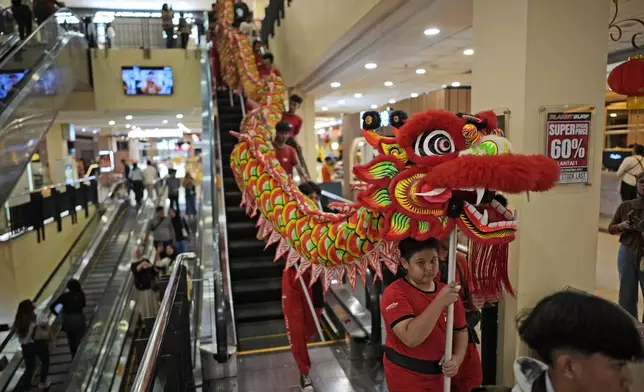 Members of dragon dance club Naga Merah Putih (Red White Dragon), named after Indonesian national colors, parade around a shopping mall during a performance in a Lunar New Year celebration, in Bogor, West Java, Indonesia, Sunday, Jan. 26, 2025. (AP Photo/Dita Alangkara)