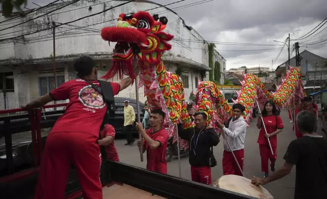 Members of dragon dance club Naga Merah Putih (Red White Dragon) which named after Indonesian national colors, carry a dragon puppet onto a truck as they prepare to leave for a shopping mall to perform in a Lunar New Year celebration, in Bogor, West Java, Indonesia, Sunday, Jan. 26, 2025. (AP Photo/Dita Alangkara)