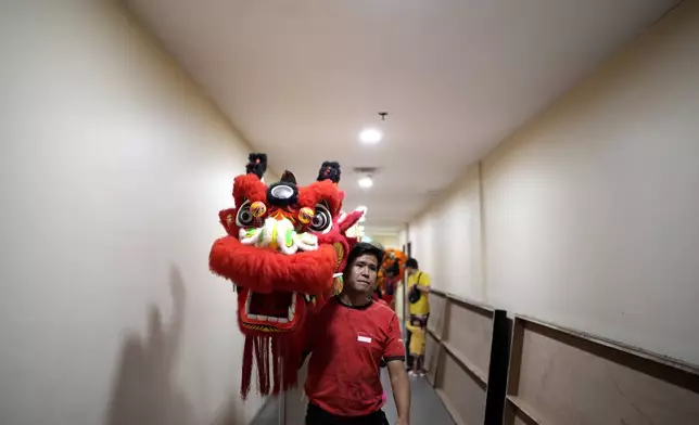 A member of dragon dance club Naga Merah Putih (Red White Dragon), named after Indonesian national colors, carry a dragon puppet as he and his team leave the changing room to perform in a Lunar New Year celebration, at a shopping mall in Bogor, West Java, Indonesia, Sunday, Jan. 26, 2025. (AP Photo/Dita Alangkara)
