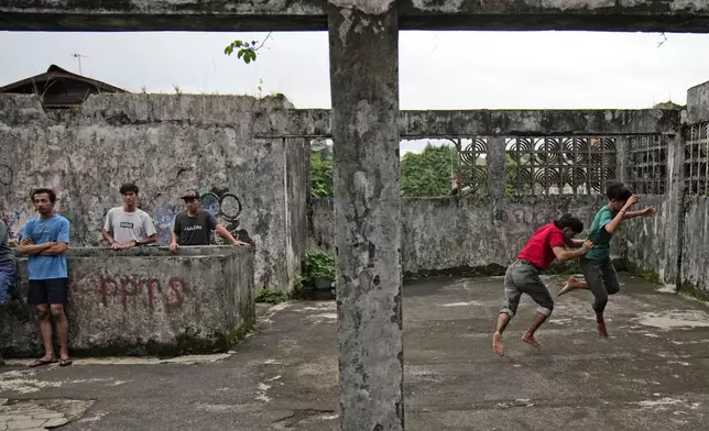 Members of dragon dance club Naga Merah Putih (Red White Dragon) which is named after Indonesian national colors, Muhammad Ilman, second right, and Muhammad Fadil, right, practice their dance movements in Bogor, West Java, Indonesia, Wednesday, Jan. 22, 2025. (AP Photo/Dita Alangkara)
