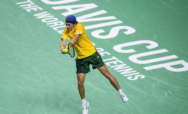 FILE - Australia's Alex de Minaur returns the ball against Italy's Jannik Sinner during the Davis Cup semifinal at the Martin Carpena Sports Hall in Malaga, southern Spain, on Saturday, Nov. 23, 2024. (AP Photo/Manu Fernandez, File)