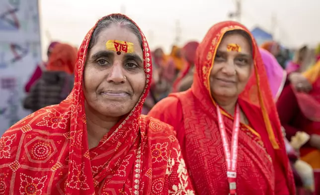 Hindu devotees have sacred marks reading 'Radhe' on their foreheads at the confluence of the Ganges, the Yamuna, and the Saraswati rivers during the 45-day-long Maha Kumbh festival in Prayagraj, India, Tuesday, Jan. 14, 2025. (AP Photo/Ashwini Bhatia)